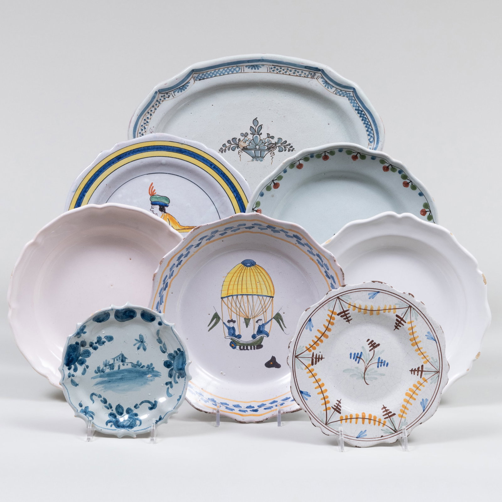 Group of Faience Tableware: Group of Faience Tableware Various designs and marks. Comprising: Fourteen plates Four side plates An oval platter The larger plates 9 1/2 in. diam., (19 pcs).