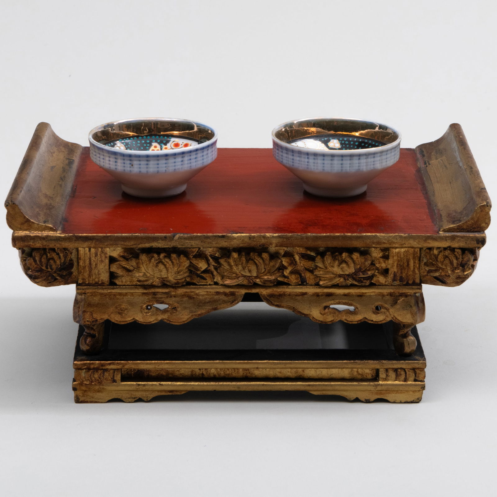Japanese Miniature Giltwood Altar and a Pair of Porcelain Saki Bowls: Japanese Miniature Giltwood Altar and a Pair of Porcelain Saki Bowls The altar 4 x 8 1/2 x 5 1/2 in., the bowls 1 1/8 x 2 1/2 in. diam. The Collection of Jordan Saunders.