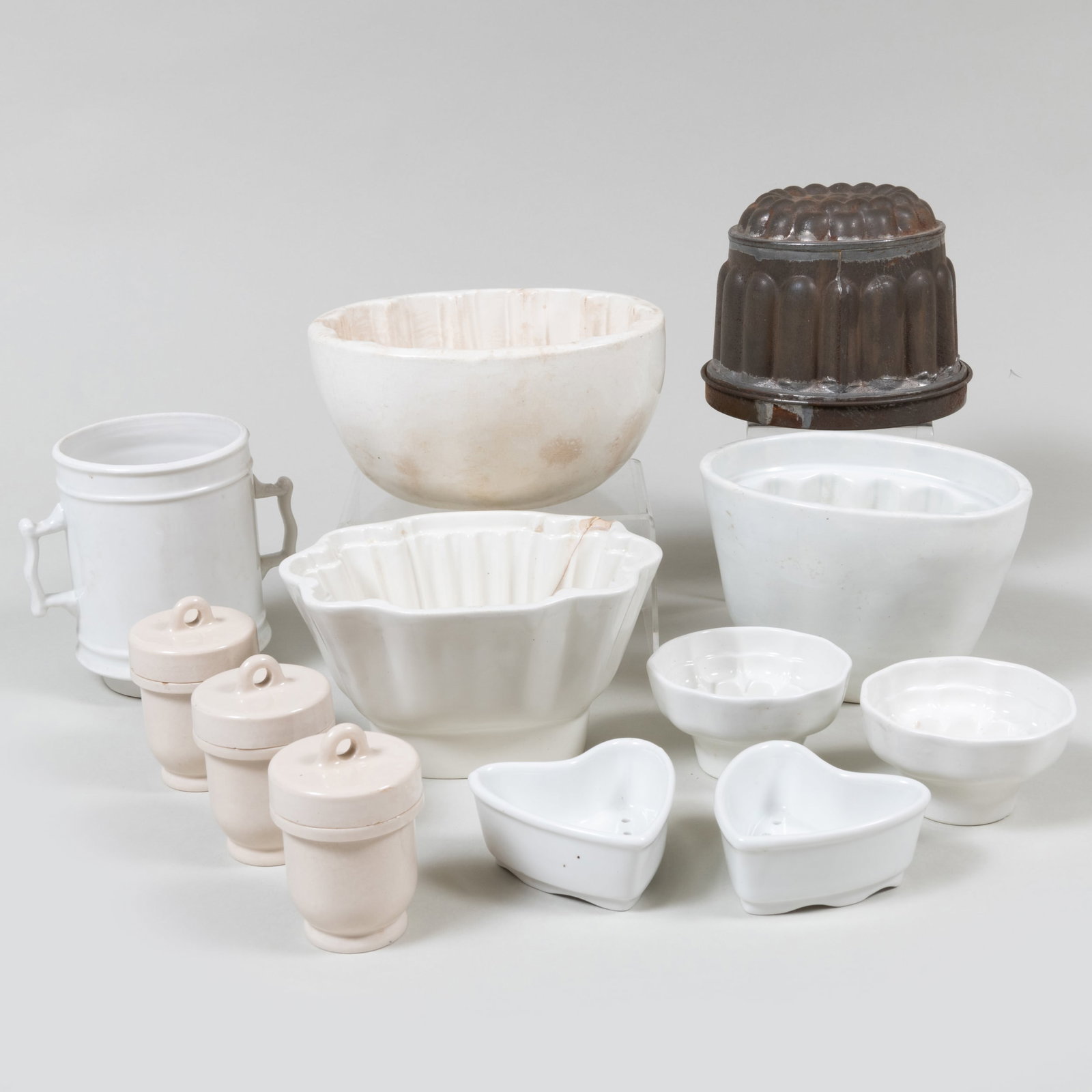 Group of Ceramic Molds and Vessels: Group of Ceramic Molds and Vessels Unmarked. Comprising: Sixteen ceramic molds of varying form Three cylindrical containers with screw tops Together with: A metal mold A ceramic mug The largest 3 3/4
