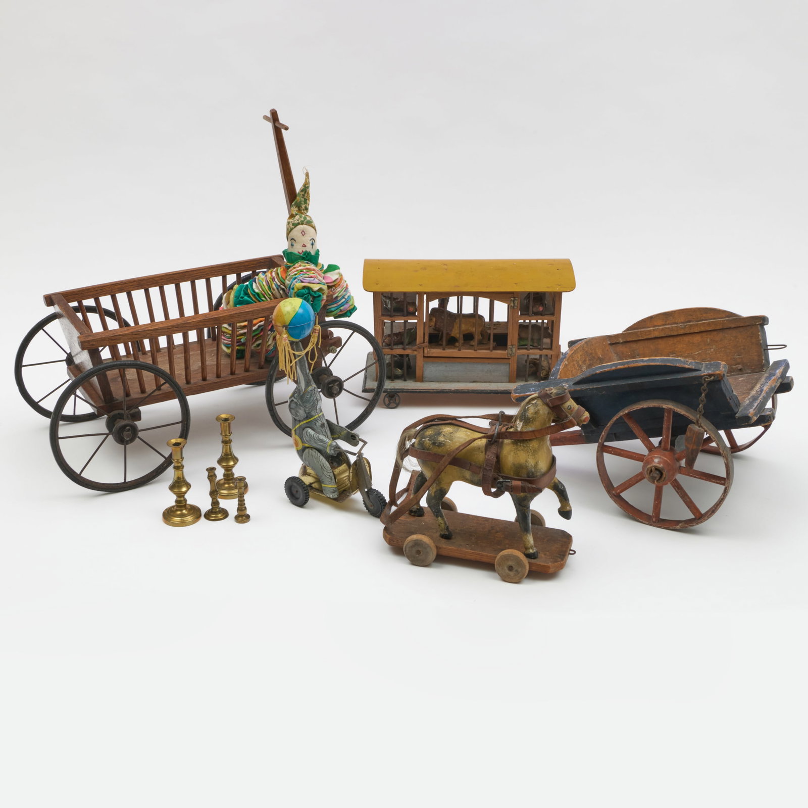 Group of Antique Children's Toys: Group of Antique Children's Toys Comprising: A wood and metal model of a wagon A painted wood model of a cart A painted wood horse pull toy A painted wood model of a circus car A painted tin