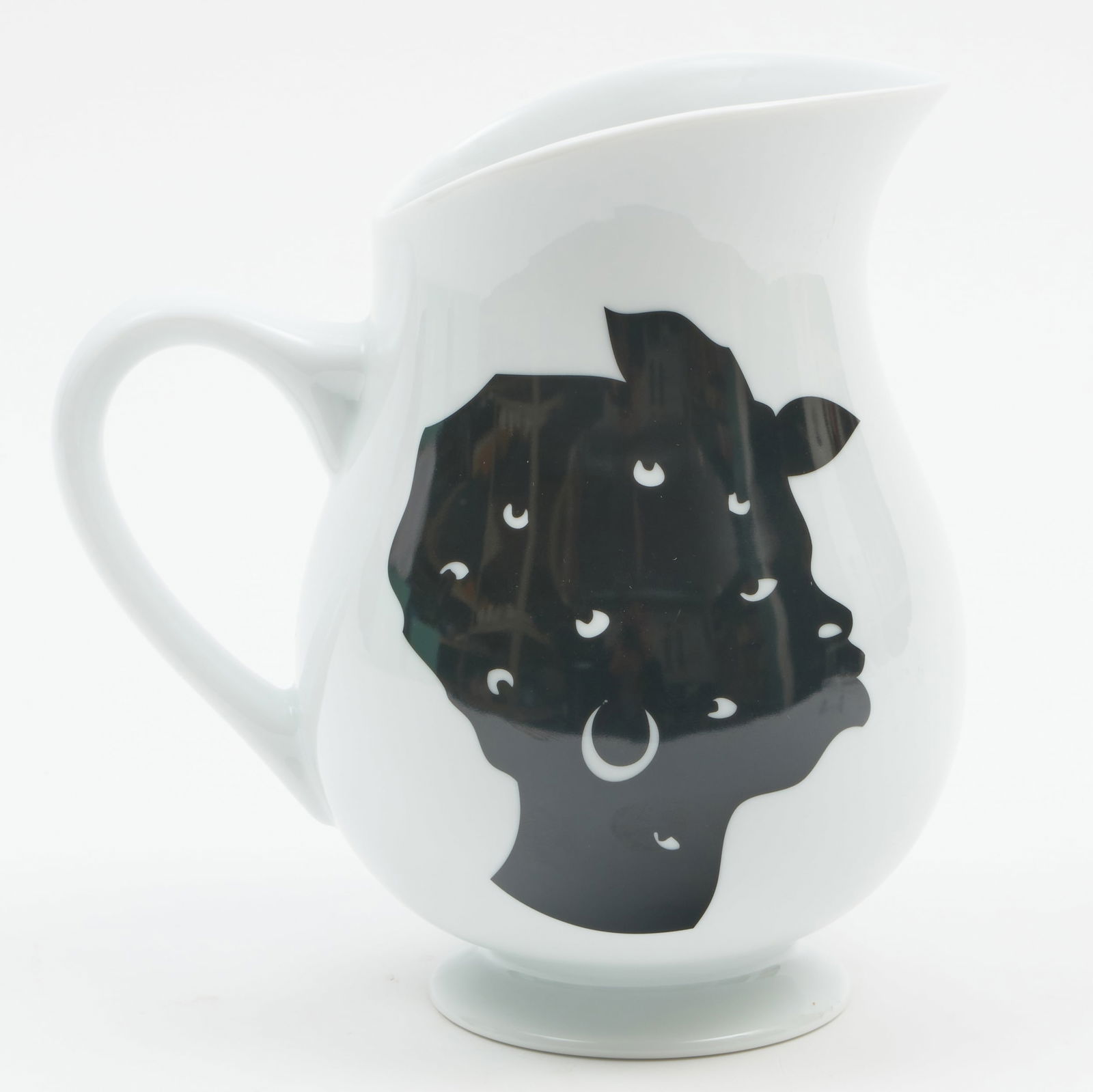 Kara Walker for Bernardaud Porcelain Pitcher: Kara Walker for Bernardaud Porcelain Pitcher Black printed mark, ed. ?/1000. 8 1/4 x 7 1/2 x 5 3/4 in. Collection of Jordan Saunders.