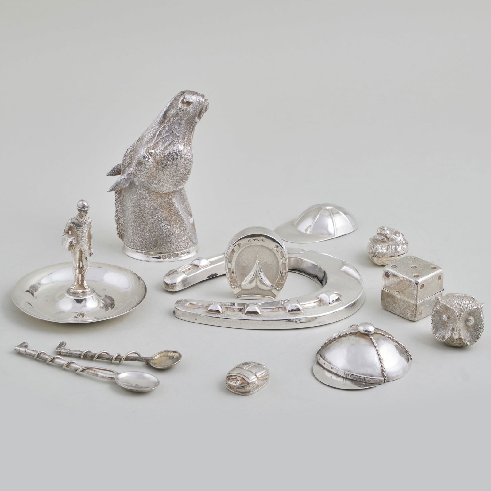 Group of Silver and Silver Plate Horseracing Themed Objects: Group of Silver and Silver Plate Horseracing Themed Objects The silver comprising: Tiffany & Co. jockey ring holder, marked 'Sterling' An Elizabeth II horse head stirrup cup, London, 1984 and 'Sterlin