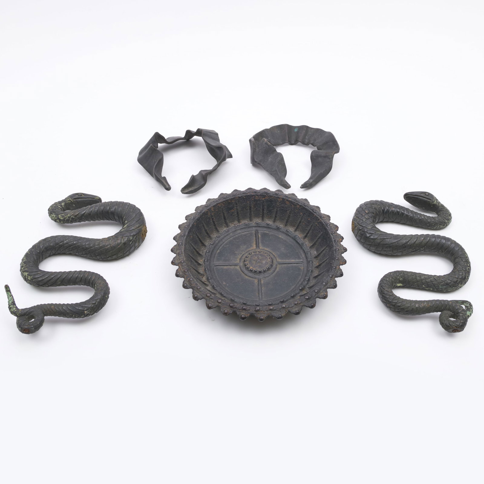 Pair of Bronze Snake Mounts: Pair of Bronze Snake Mounts Together with a pair of bronze ribbon elements and a cast iron drip pan. The bronze ribbons each marked 224. 9 1/2 x 6 1/4 x 1 1/2 in., the snakes. 6 1/4 x 6 x 2 1/4 in., t