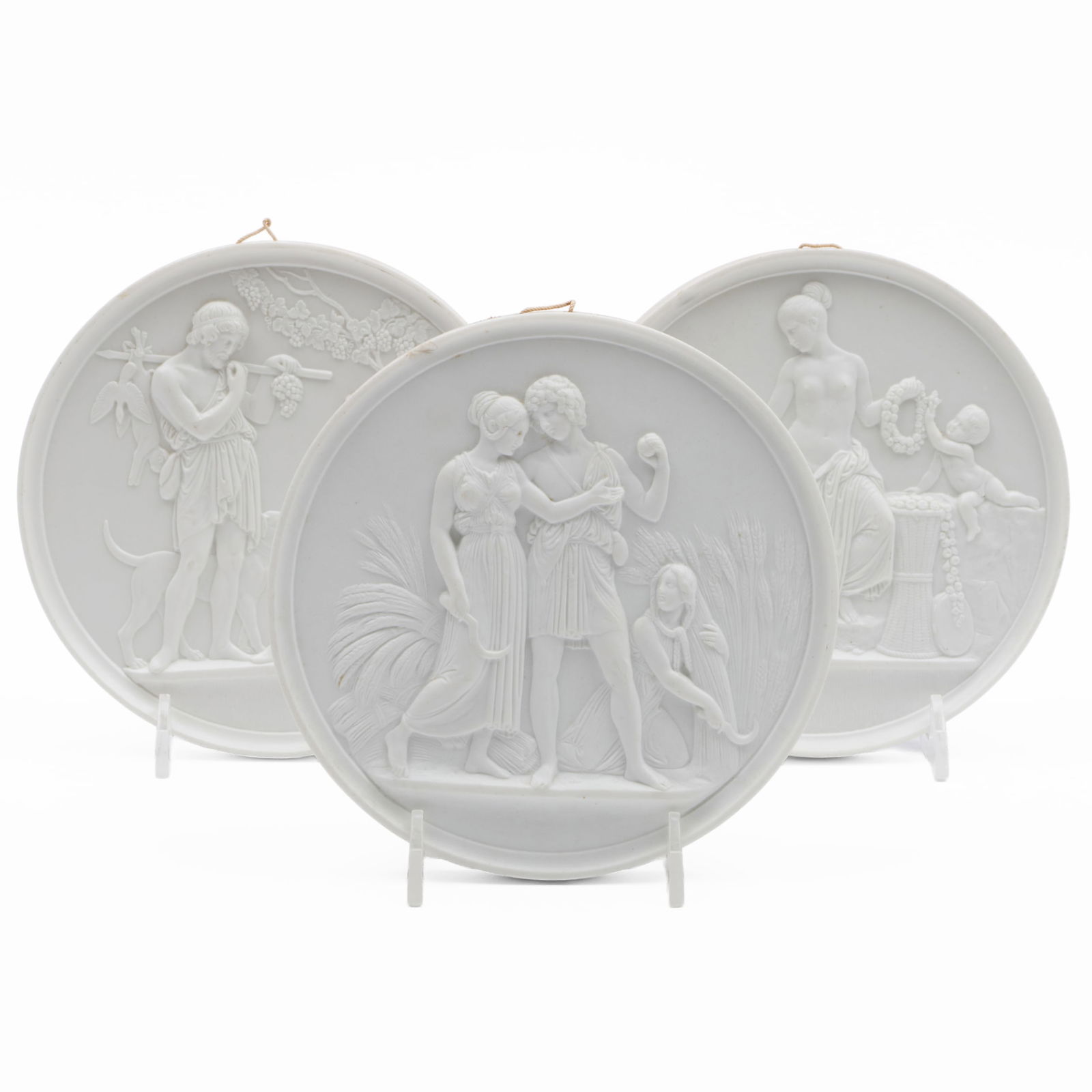 Group of Three Bing & Grondahl Bisque Porcelain Medallions Emblematic of the Seasons: Group of Three Bing & Grondahl Bisque Porcelain Medallions Emblematic of the Seasons Impressed mark. 5 3/4 in. diam. The Collection of James M. Labaugh Antiques, Pound Ridge, NY.