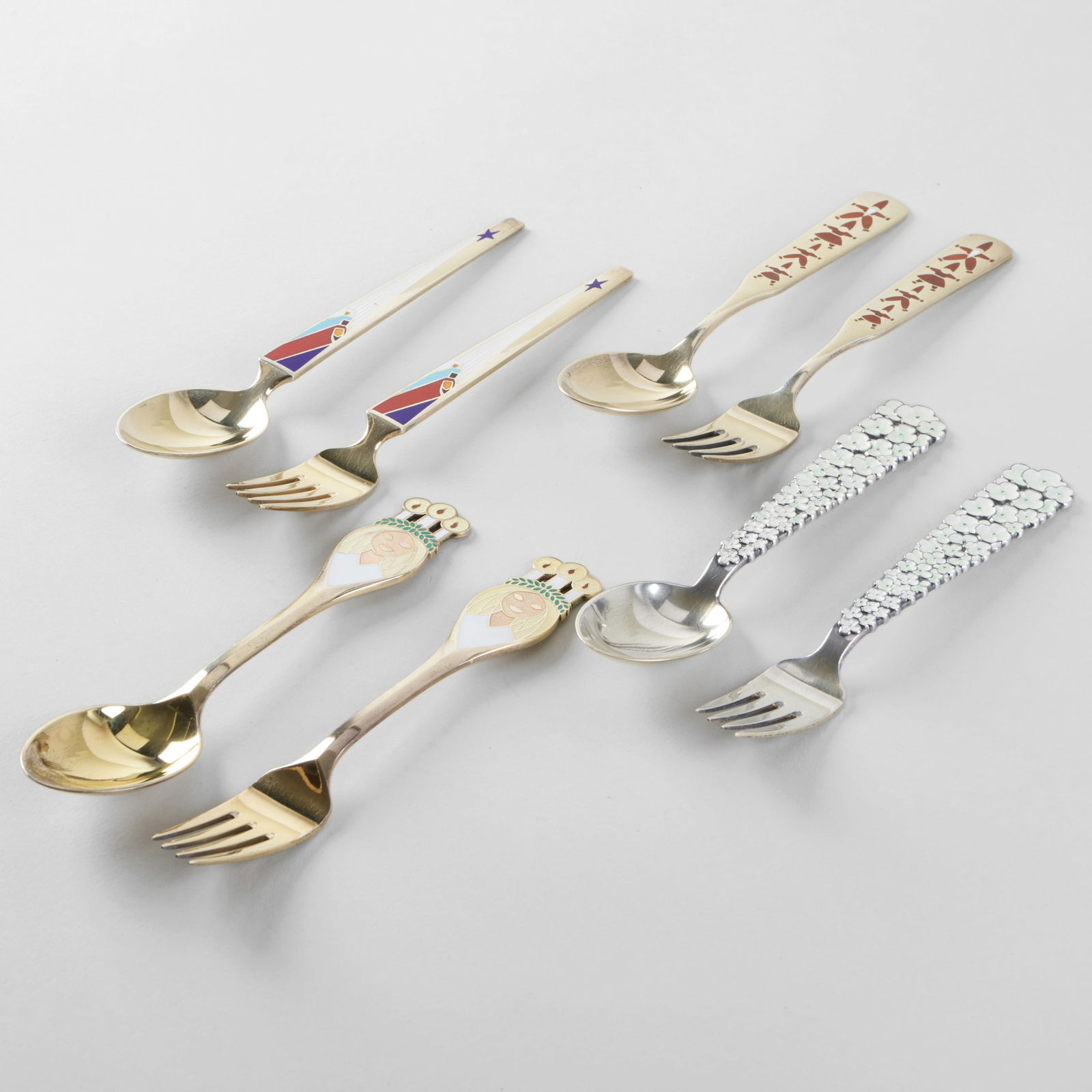 Set of Eight Jensen Silver and Enamel Commemorative Holiday Forks and Spoons: Set of Eight Jensen Silver and Enamel Commemorative Holiday Forks and Spoons Comprising: 1956 'Snow Flowers' spoon and fork, designed by Jørgen Michelsen, mark of A. Michelsen and 'Sterling' 19