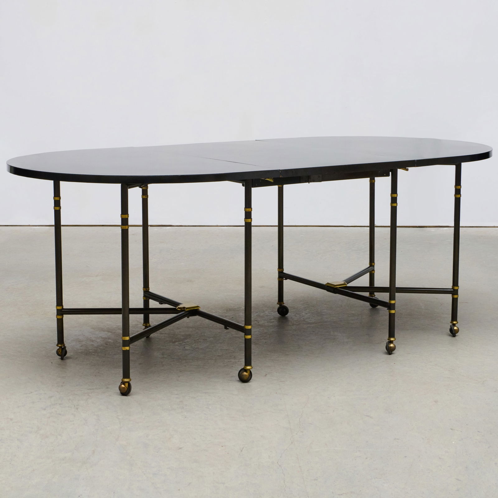 Maison Jansen Patinated-Metal and Black Laminate Dining Table: Maison Jansen Patinated-Metal and Black Laminate Dining Table Raised on casters. 29 1/2 x 4 ft. 7 x 39 1/4 in. (closed, without leaf). Single leaf 39 1/4 x 23 1/2 in. Sold STAIR, June 2024, Lot 189.