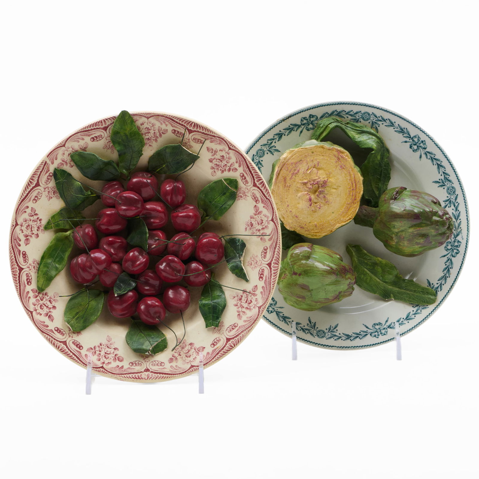 Two Christine Viennet Porcelain Trompe L'oeil Plates: Two Christine Viennet Porcelain Trompe L'oeil Plates Painted signature. Comprising: A plate of cherries A plate with artichokes Each approx. 9 1/4 in. diam. Property from the Collection of a Prominent