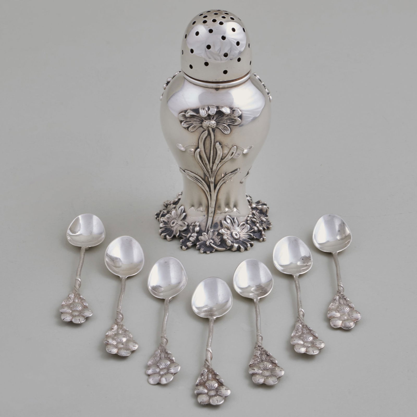 American Silver Caster and a Set of Seven Coffee Spoons with Flower Handles: American Silver Caster and a Set of Seven Coffee Spoons with Flower HandlesEach marked 'Sterling'.The caster 5 1/2 x 2 3/4 in. diam., the spoons 4 in. long, 8.8 oz. approx. weight.Sold STAIR,