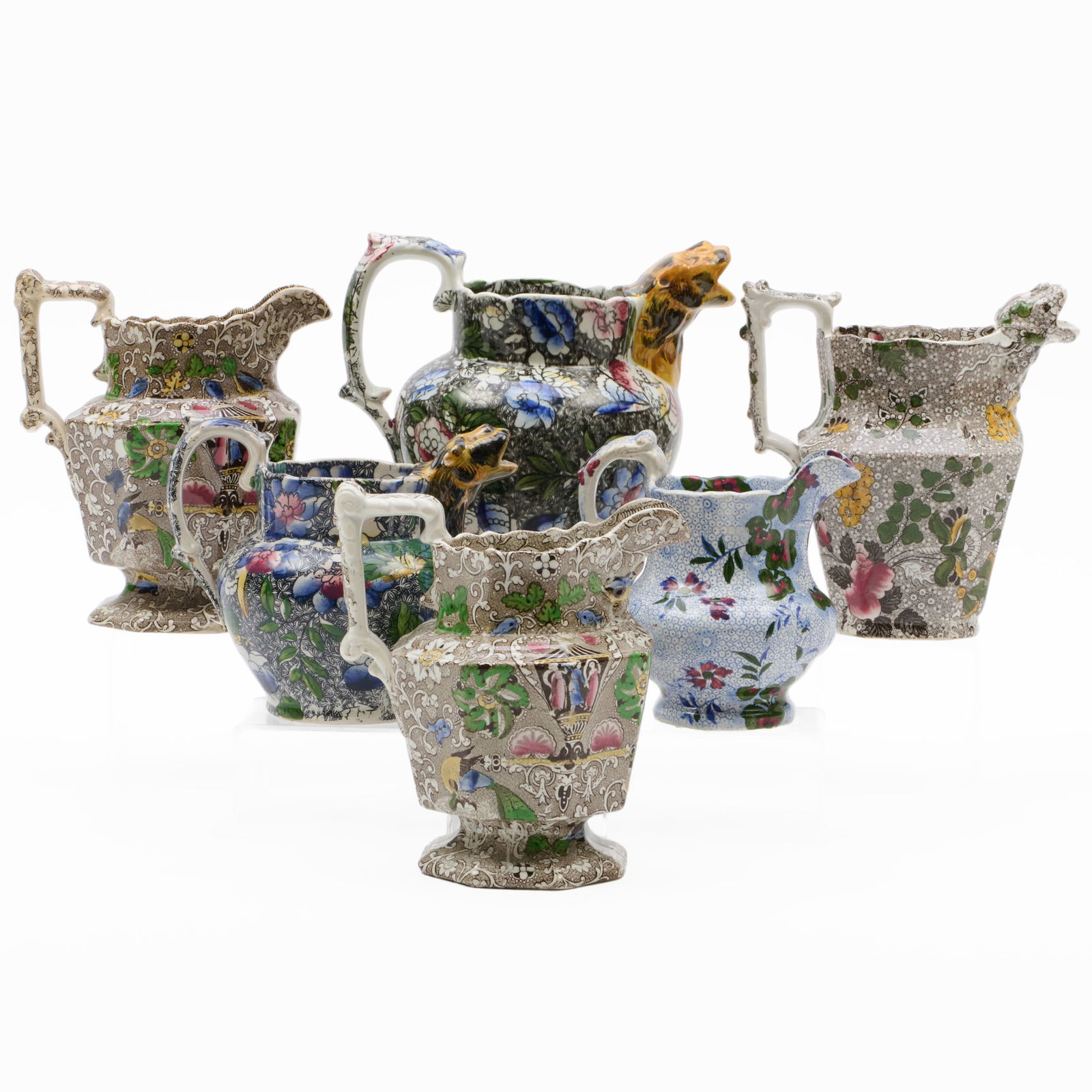Group of Six Victorian Transfer Printed 'Chintz' Jugs of Various Size: Group of Six Victorian Transfer Printed 'Chintz' Jugs of Various Size Comprising: Two similar black ground jugs with polychrome lion mask spouts in two sizes, unmarked Two similar brown ground jugs de