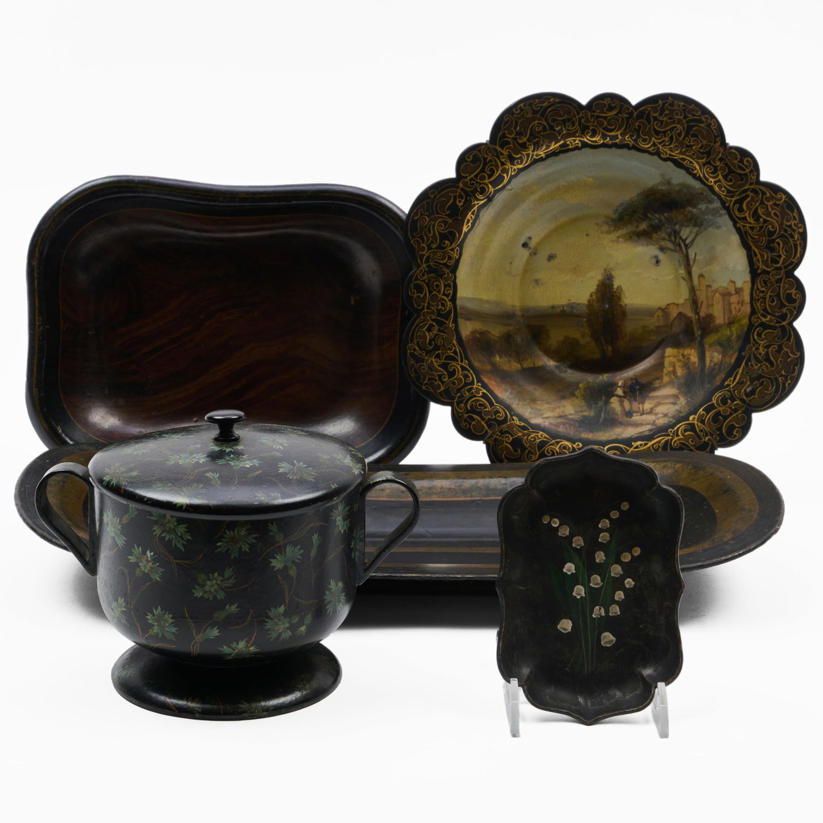 Group of Four Papier-Macha and One Tole Table Articles: Group of Four Papier-Macha and One Tole Table Articles The circular painted dish is stamped Jennens & Bettridge. The largest, 16 1/4 x 8 1/4 in., the smallest, 5 x 3 14 in. The Collection of Alan and