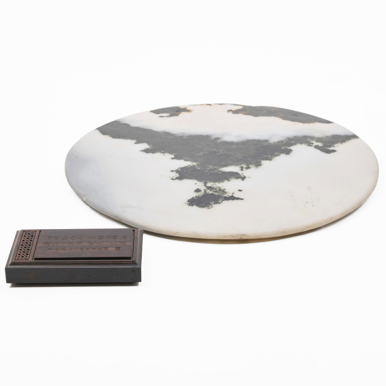 Chinese Dreamstone and a Hardwood Puzzle Box: Chinese Dreamstone and a Hardwood Puzzle Box Each with incised character marks. The stone 10 3/4 in. diam., the box 3 5/8 x 2 x 3/4 in. Collection of Nancy McClelland.