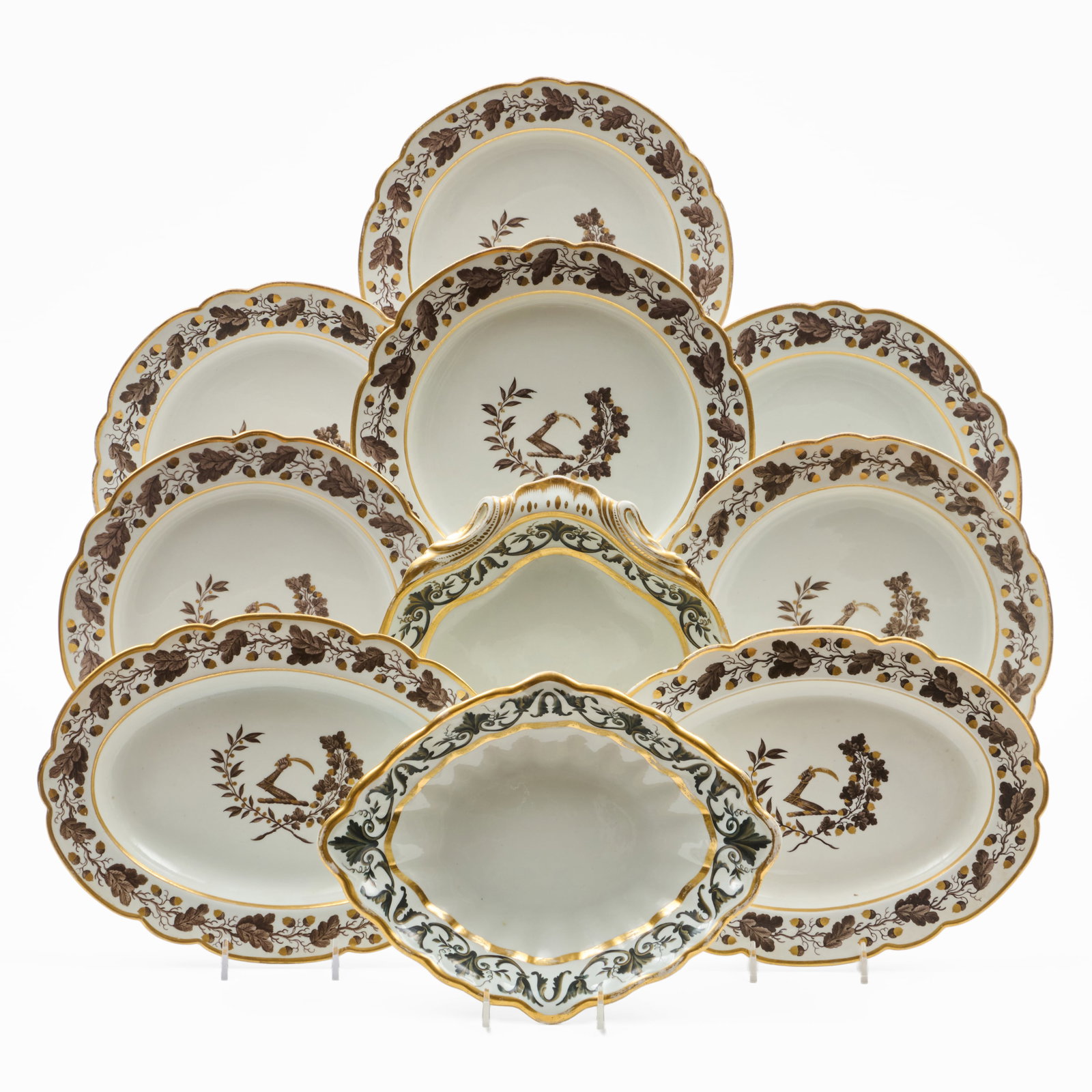 English Porcelain Part Service Decorated with Crest En Grisaille: Unmarked.Comprising:Six platesA pair of standsTogether with:A Derby navette dish, iron red markA shell dish, iron red markThe plates 9 1/2 in. diam., (10 pcs).