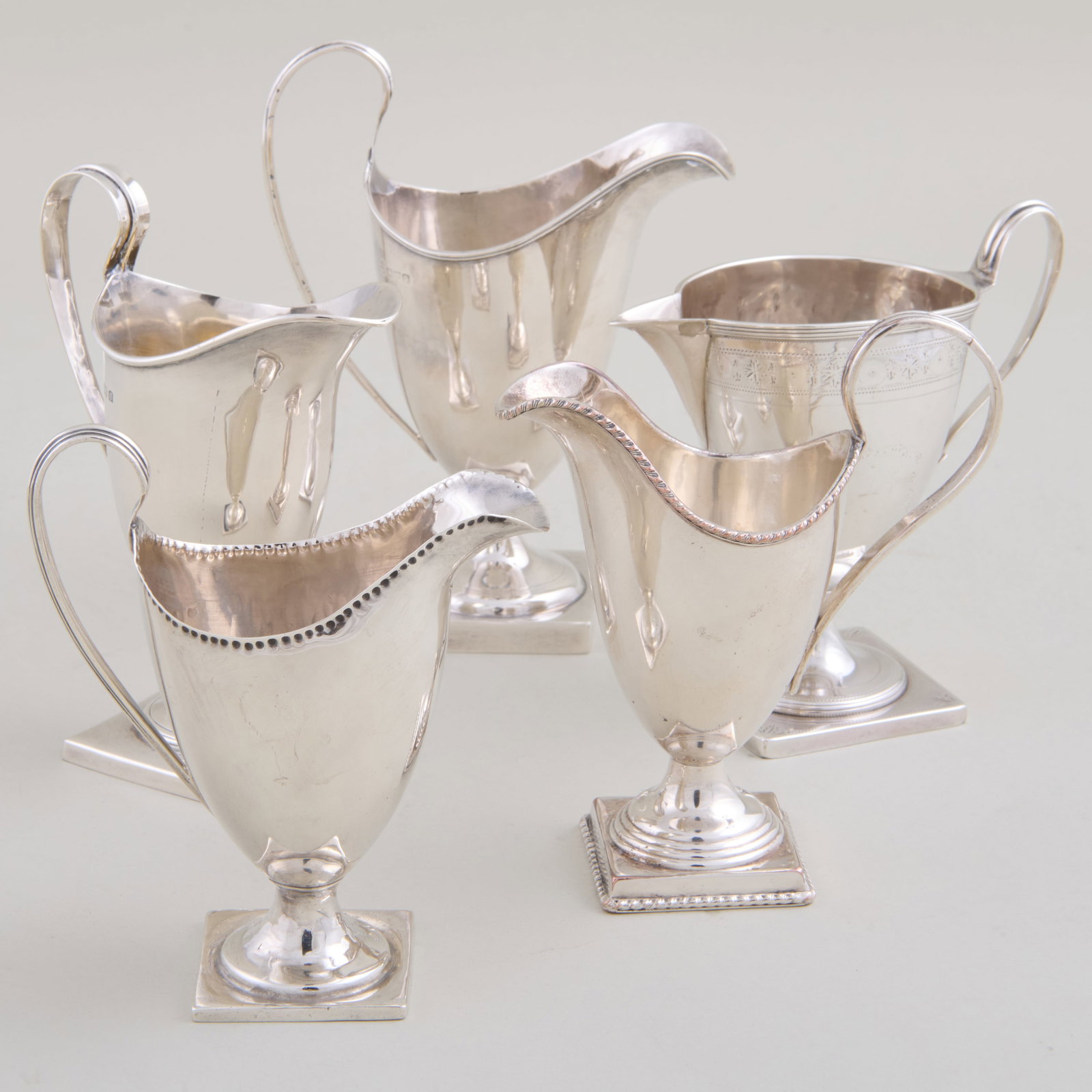 Group of Six English Silver Milk Jugs: Variously marked.Comprising:Three jugs, marked Birmingham, one weightedTwo jugs, marked LondonA jug, possibly marked ExeterTogether with a similar silver plate jugThe largest 6 x 4 3/4 x 2 5/8 in.,