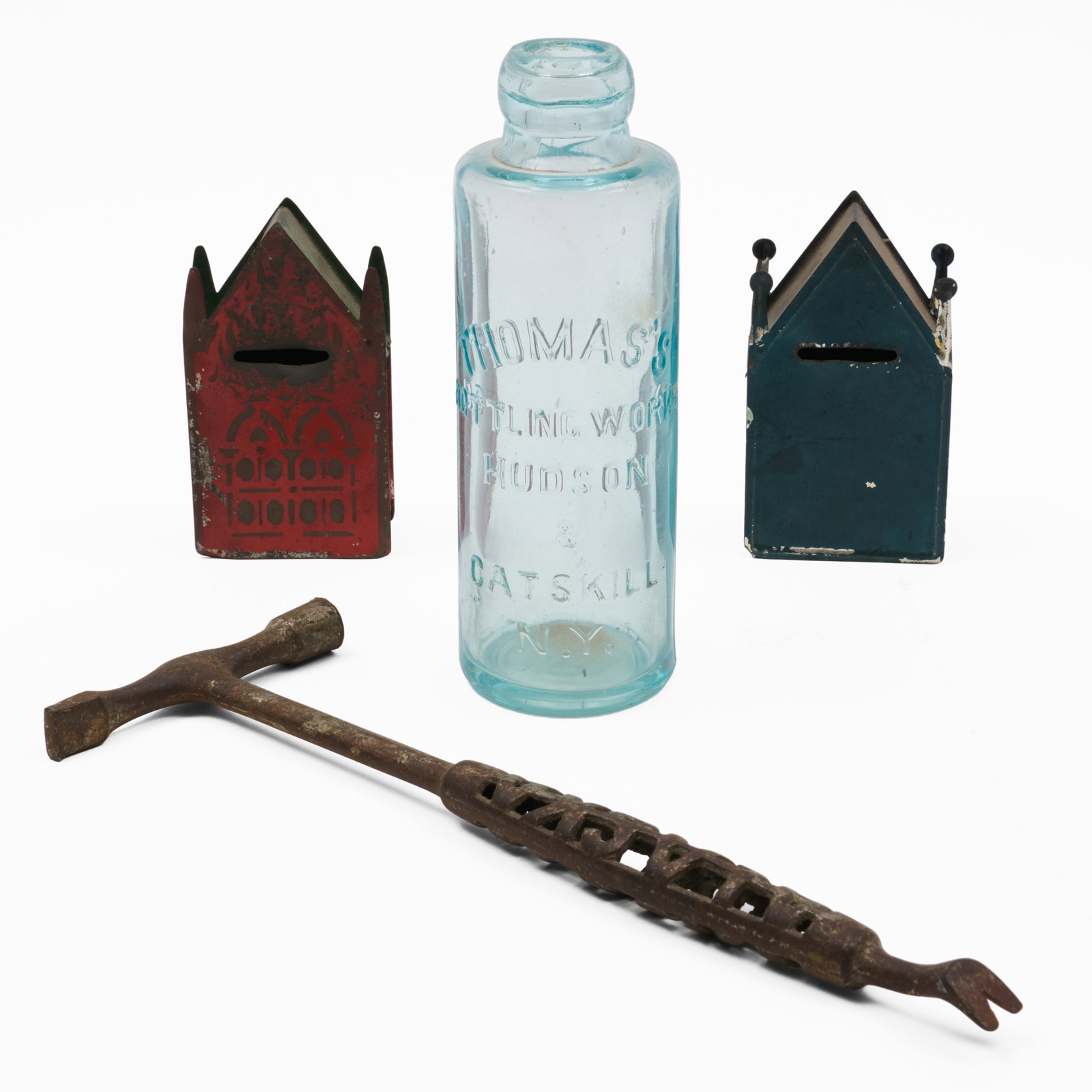 Group of Metal and Glass Articles: Group of Metal and Glass Articles Comprising:A glass bottle marked 'Thomas's Bottling Works Hudson & Catskill, NY'Two blue and red tin 'Gothic' house form coin banksAn Alaska Stove Co. advertising