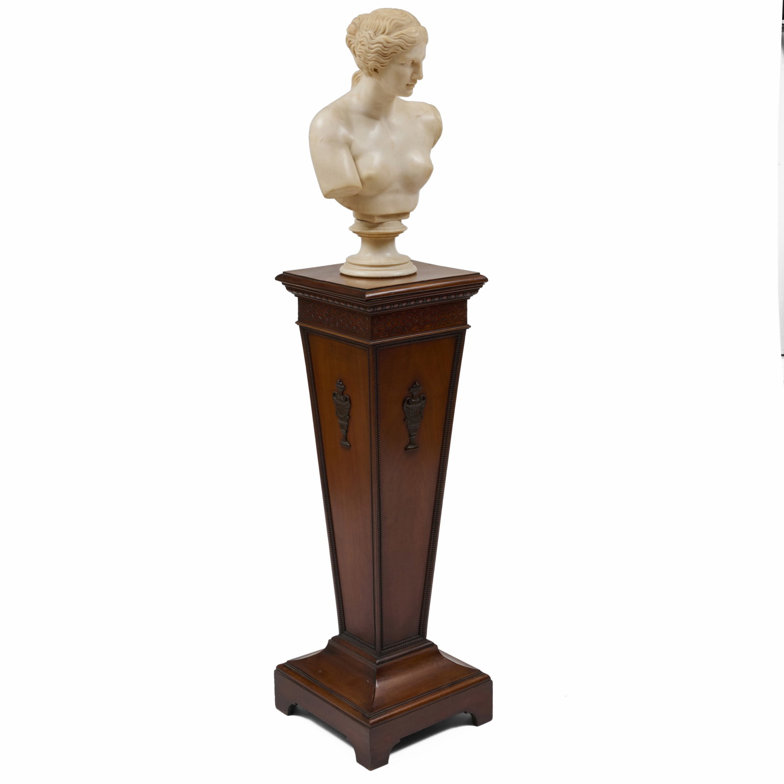 Marble Bust Of A Woman Raised On A Mahogany Pedestal: Marble Bust Of A Woman Raised On A Mahogany Pedestal In two parts.The bust 25 1/2 x 13 1/2 x 7 1/2 in.The pedestal 41 x 14 x 14 1/4 in. Property from the Collection of a Distinguished NY Lady