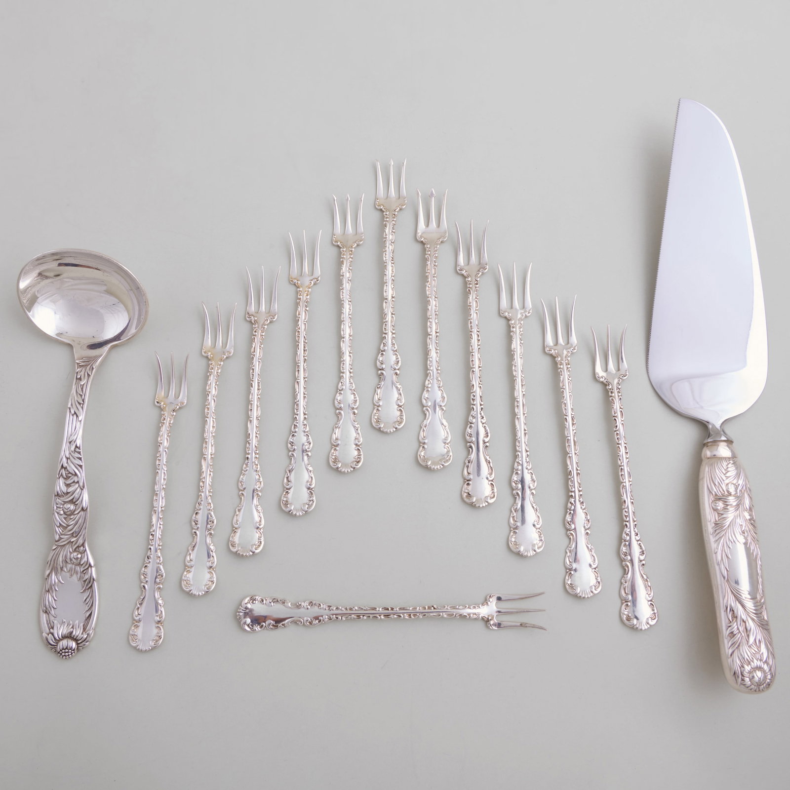 Tiffany & Co. 'Chrysanthemum' Silver Servers and a set of Twelve Whiting Cocktail Forks in the: Tiffany & Co. 'Chrysanthemum' Silver Servers and a set of Twelve Whiting Cocktail Forks in the 'Louis XV' Pattern Each marked 'Sterling'.The servers comprising:A gravy ladle A pie server with steel