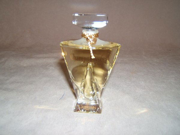 "CHAMPS ELYSEES" PARFUM BY GUERLAIN 1 OZ IN BOX: "CHAMPS ELYSEES" PARFUM BY GUERLAIN 1 OZ IN BOX - The fine crystal flacon is 4 x 3 inches at the shoulder. 1 x 1 1/4 inch logo marked stopper, gold security seal & tag. NIB. With fitted box & outer ca