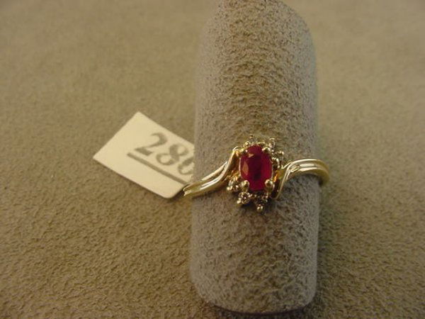 10K GOLD RUBY AND DIAMOND RING: 1 10K GOLD RING SET WITH 1 OVAL RUBY & 6 DIAMONDS SIZE 5 3/4 - GRAM WEIGHT: 1.5