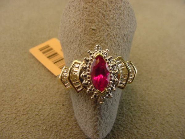 10K GOLD RUBY AND DIAMOND RING: 1 10K GOLD RING SET WITH 1 CREATED RUBY & 2 ROUND & 4 BAGUETTE CUT DIAMONDS SIZE 7 - GRAM WEIGHT: 3.0