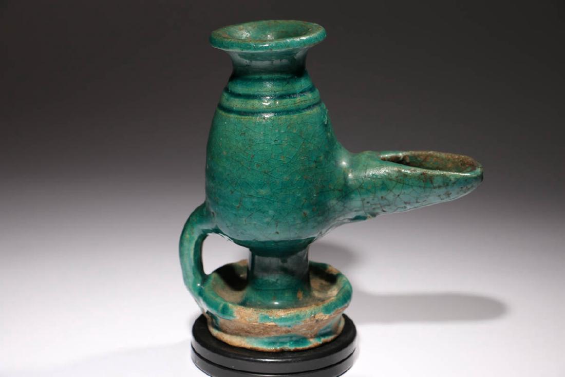 Islamic Ceramic Oil Lamp: Large lamp, ca. 12 - 14 century. A.D. Turquoise glaze, with crazing, long spout, looped handle. Dimensions: 5-1/2" H; Weight: 14 oz. Provenance: Ex. L Stewart collection, NY