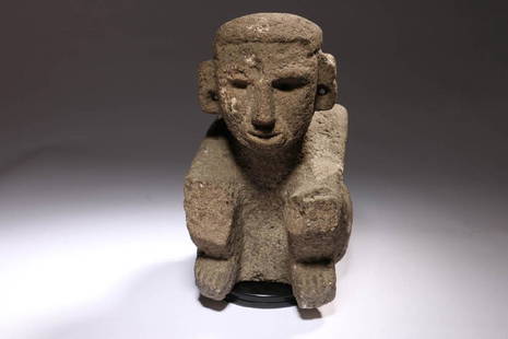 Pre-Columbian Stone Figure: Costa Rican Stone Figure, ca. 1000 - 1500 A.D. A volcanic rock stone figure of a squatting man, nicely detailed face, large holed earlobes, hair pulled back with adorned pony tail. Arms resting on kne