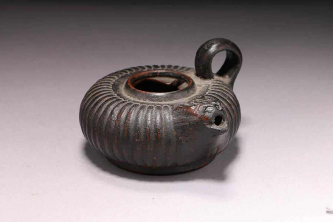 Black-Glazed Guttus: A South Italian Guttus, 4th century, ribbed body, molded lion head spout, looped handle, 4-3/8" dia. Provenance: Ex private collection, Belgium.