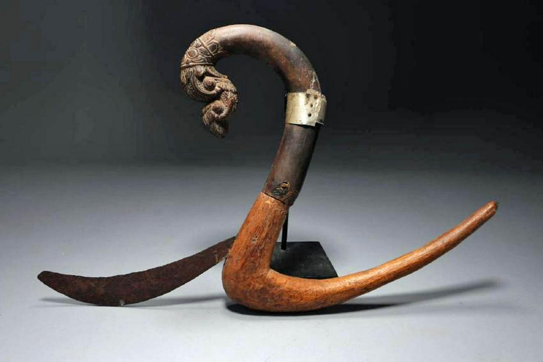 Indonesian Rice Scythe: A wood and iron rice scythe with dragon handle, and metal band. Dimensions: 12" H; Weight: 9.5 oz. Provenance: Ex. Private collection, Pennsylvania. NOTE: This lot has a reserve.