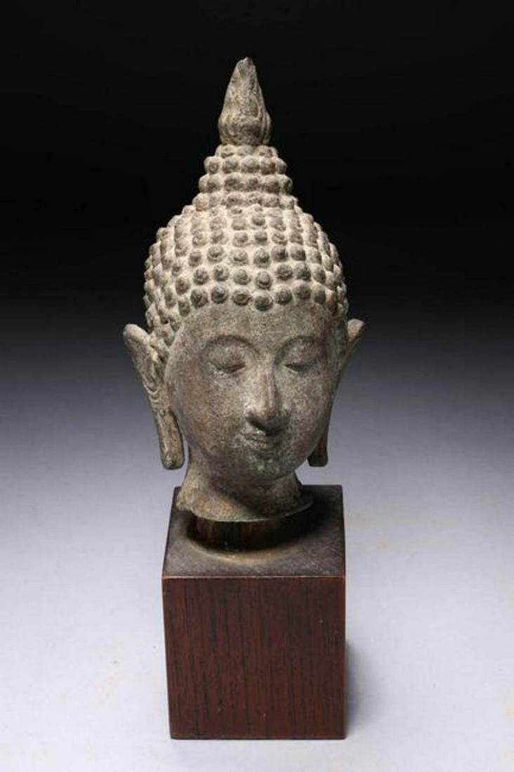Bronze Buddha Head: A bronze Buddha head with flame and elongated ears