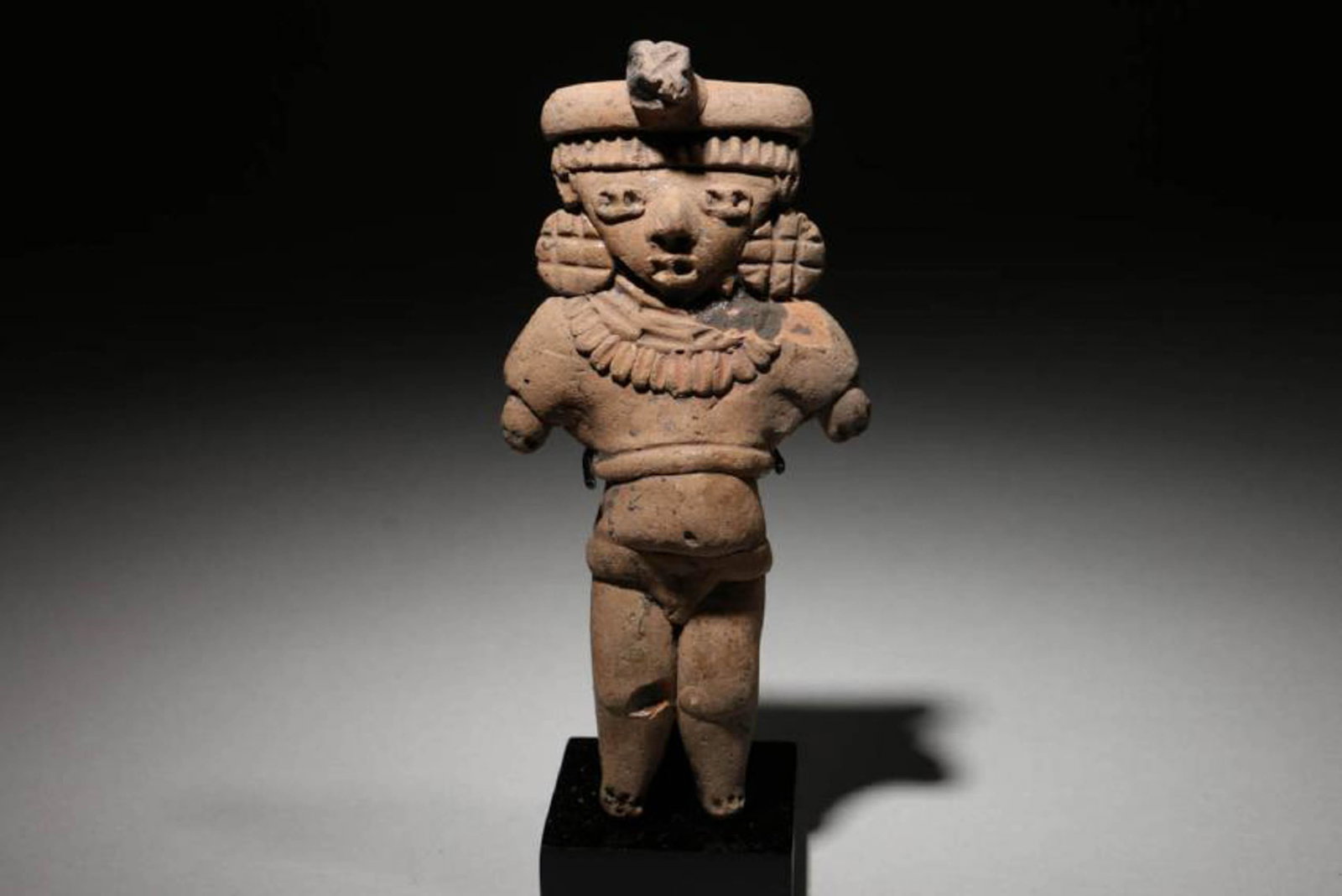 Pre-Columbian terracotta MichoacÃ¡n "Pretty Lady": Pre-Columbian, Western Mexico, MichoacÃ¡n, circa 500 - 100 B.C. A finely detailed terracotta female "Pretty Lady" figure. Standing with arms at side, donning a headdress with protruding element, lar