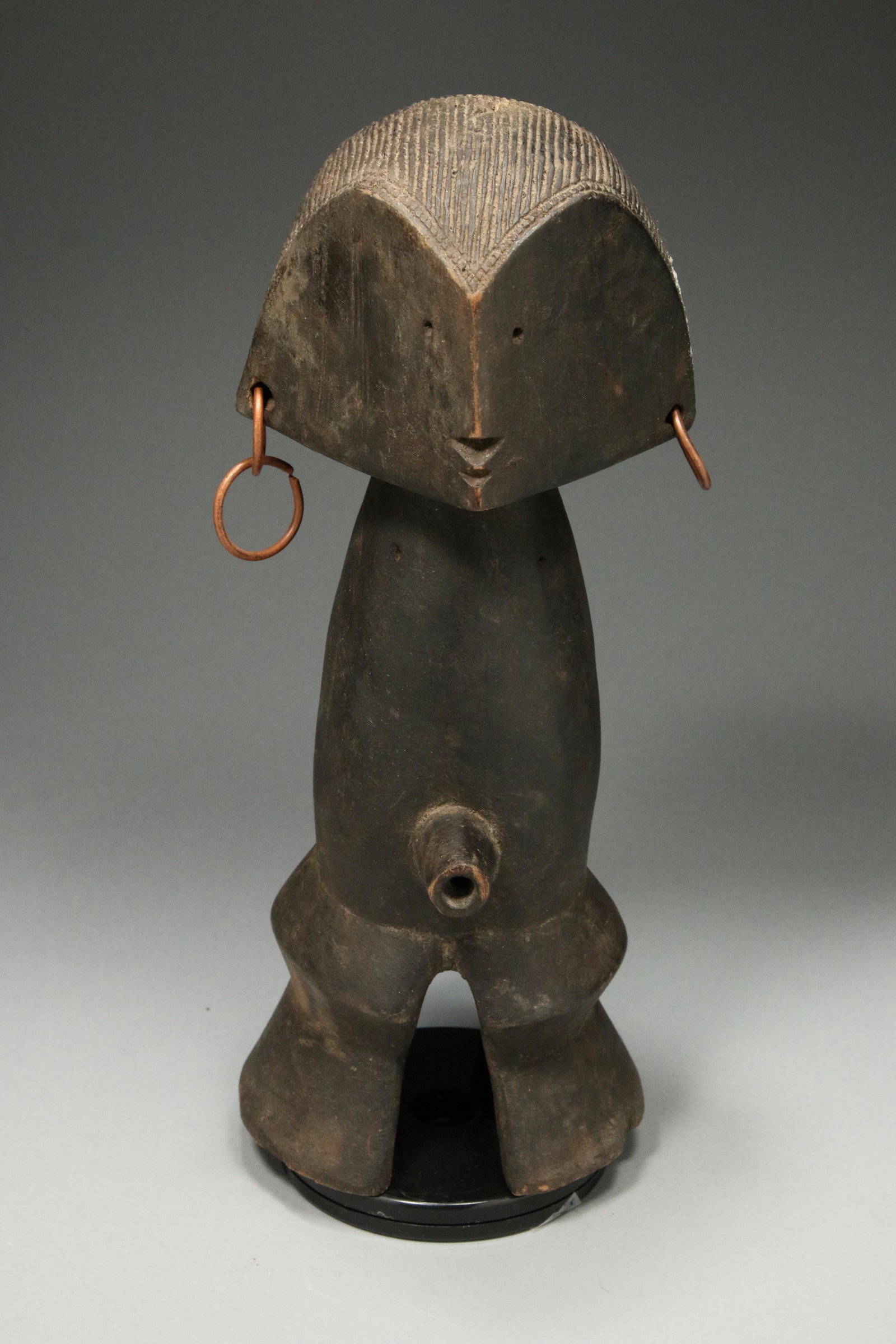 African Art Wood Sculpture: A Central Africa wood statue with copper earrings. 13" H