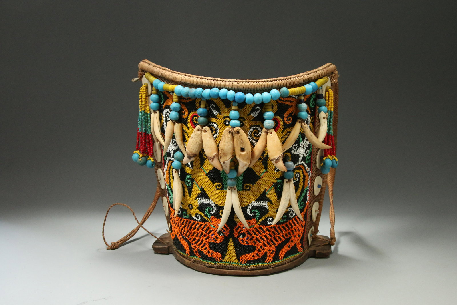 Indonesia Borneo Kenyah Dayak Ba Beaded Baby Carrier: Indonesia Central Borneo Kenyah Dayak Ba or baby carrier (Mid 20th Century) constructed of woven rattan with a wooden crescent shaped base and fine detailed beadwork designs in orange, yellow, white,