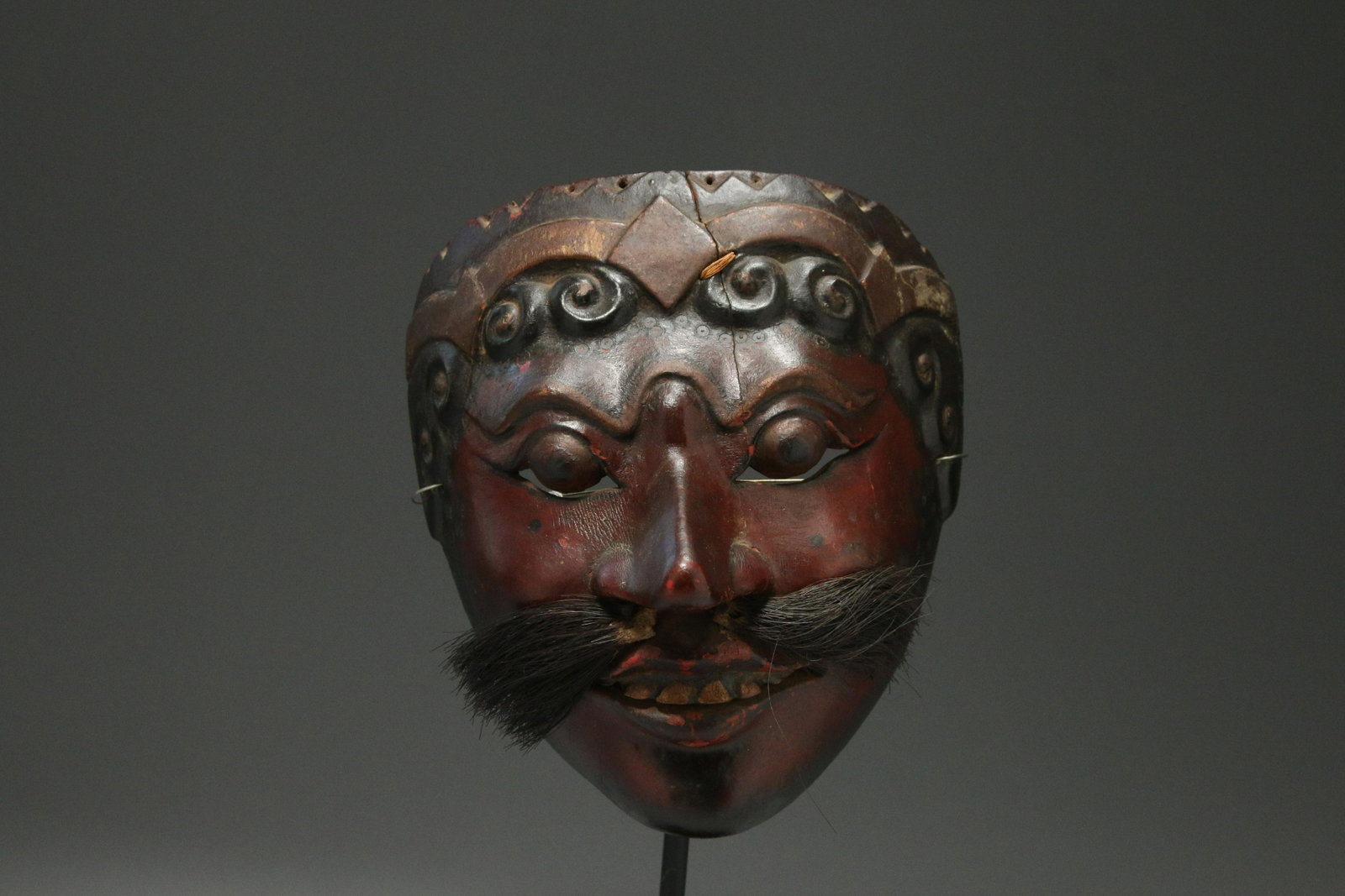 Antique Wayang Topeng Theatre Mask, Indonesia: Antique Javanese carved and polychrome wood mask / wayang topeng, with long nose, horse hair moustache, wearing a crown. tongued mouth holder in interior. 7-1/2" H red lips and gold teeth under horse 