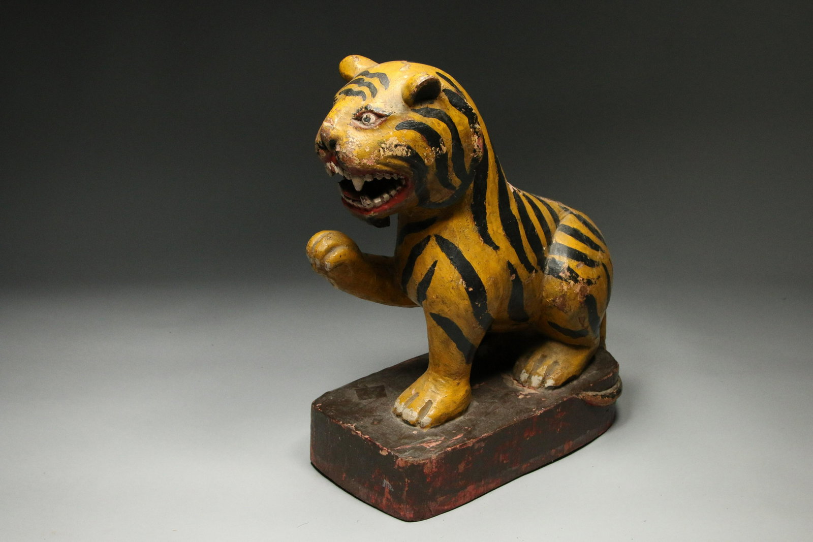 Indonesian Wood Tiger: A carved wood tiger, with paw in air. 14" H x 11" L; 9 lbs
