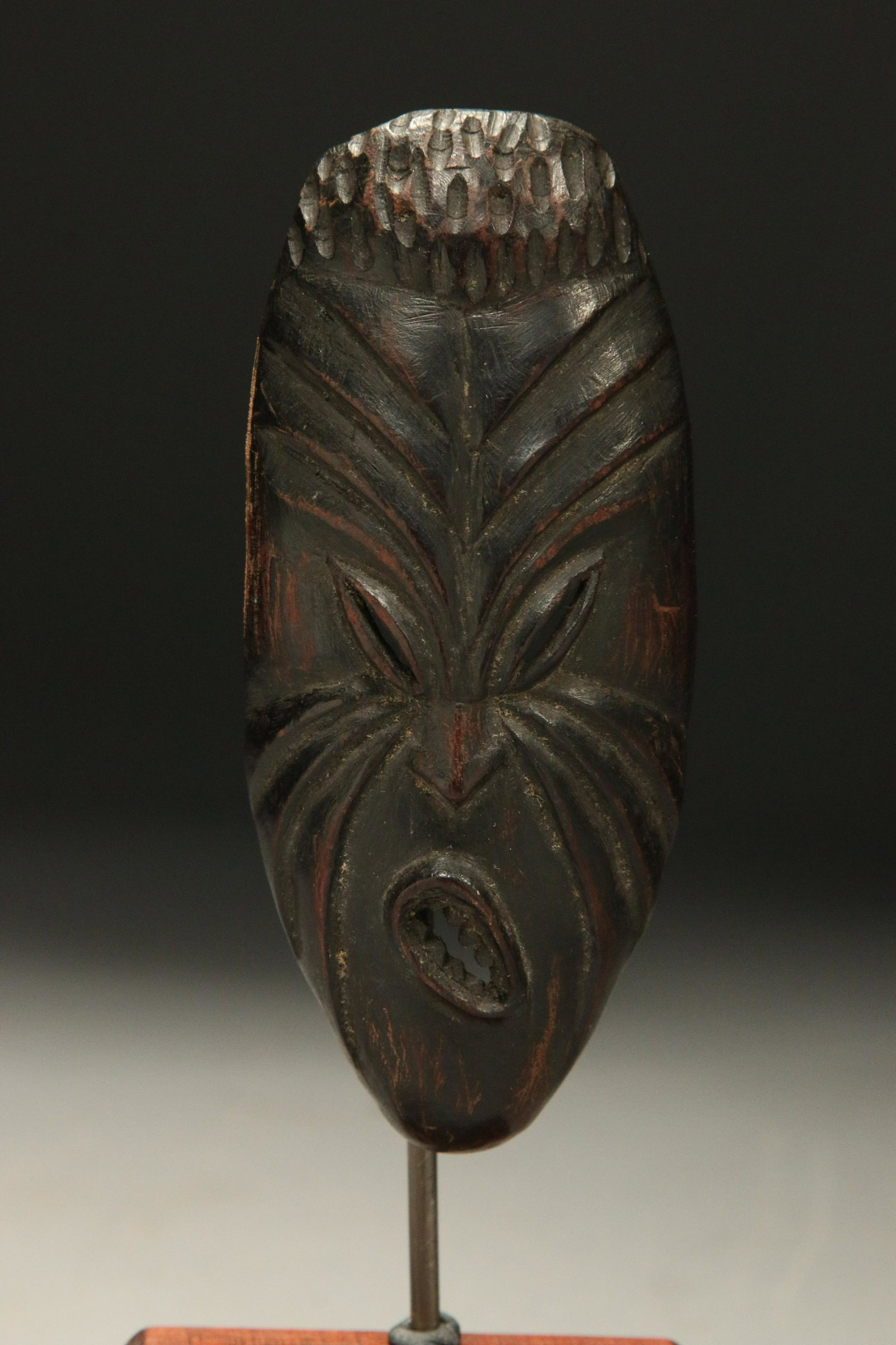 South Pacific Maori Mask: A Maori wood passport mask with intricate carving of a grimencing face. Display stand included. 4-1/4" H (w/o stand). Provenance: Ex. Collection, New Hampshire