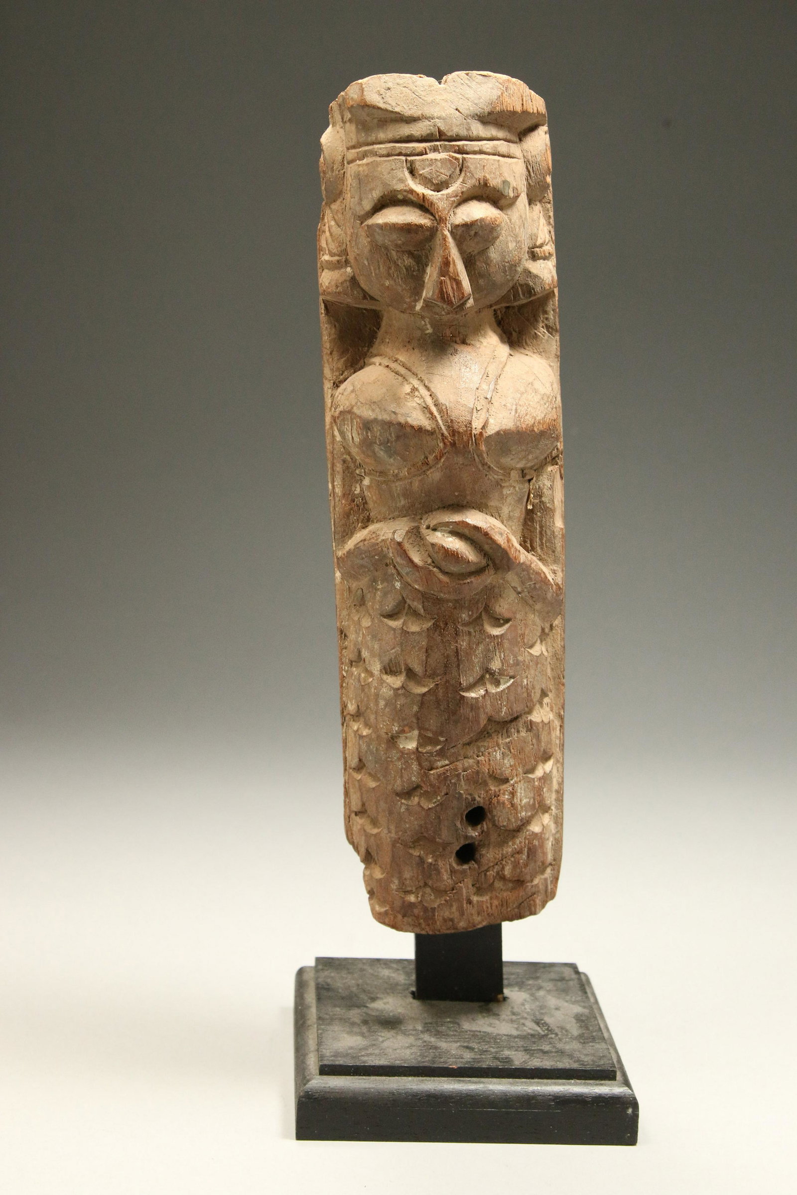 Southeast Asia Statue: A wood statue of a crowned female, holding object at waist. Display stand is included. 10" H