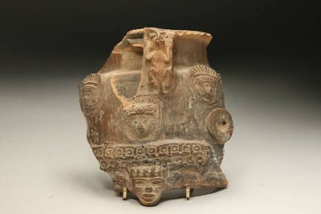 Pre-Columbian Fragment: A pottery fragment with four faces and a lizard. 7" H x 5-1/2" W.