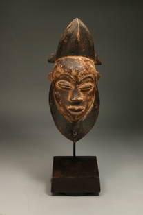 African Art Punu Mask - Gabon: A wood Punu mask, remains of Kaolin. These masks were danced by male stilt dancers called "mukudj", 12" H. Display stand is included. Provenance: Ex Holland collection.