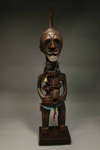 African Art Songye Statue: A Songye fetish male statue, wood, patina, leather, beads, horn, metal and leather. 28" H; 7 lbs. Display stand is included. Provenance: Ex. Collection Sammy Bopro, Belgium.