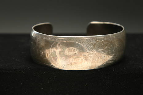 Native American Silver Bracelet - NW Coast: A large silver bracelet with bird and fish design, signed "T…Wins". 30.6 grams; 2-5/8" dia.