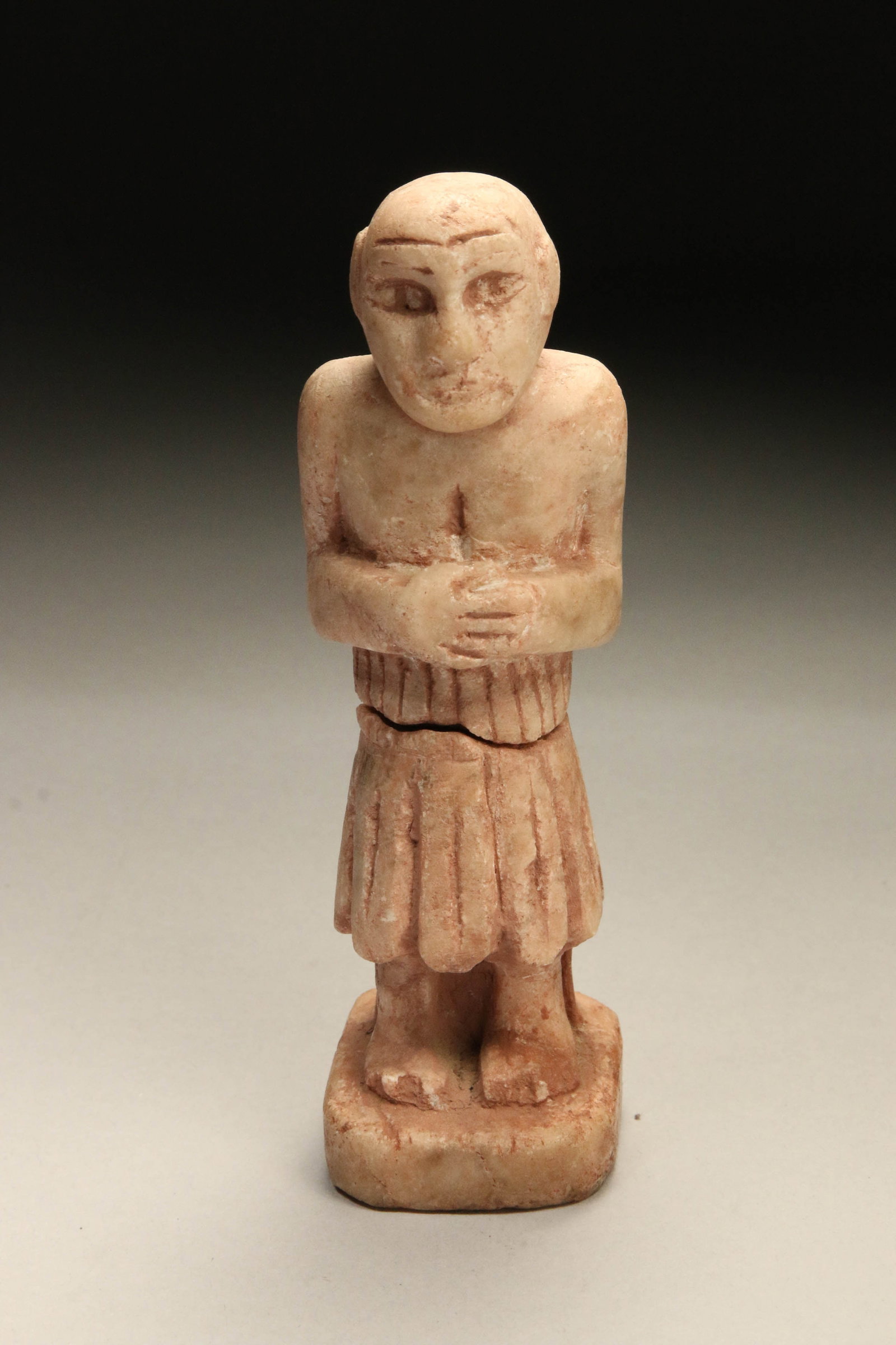 Sumerian Stone Figure: A Sumerian stone figure with hands crossed at chest, wearing a robe, carved figures on reverse. 5-3/4" H Provenance: Ex collection, New Hampshire