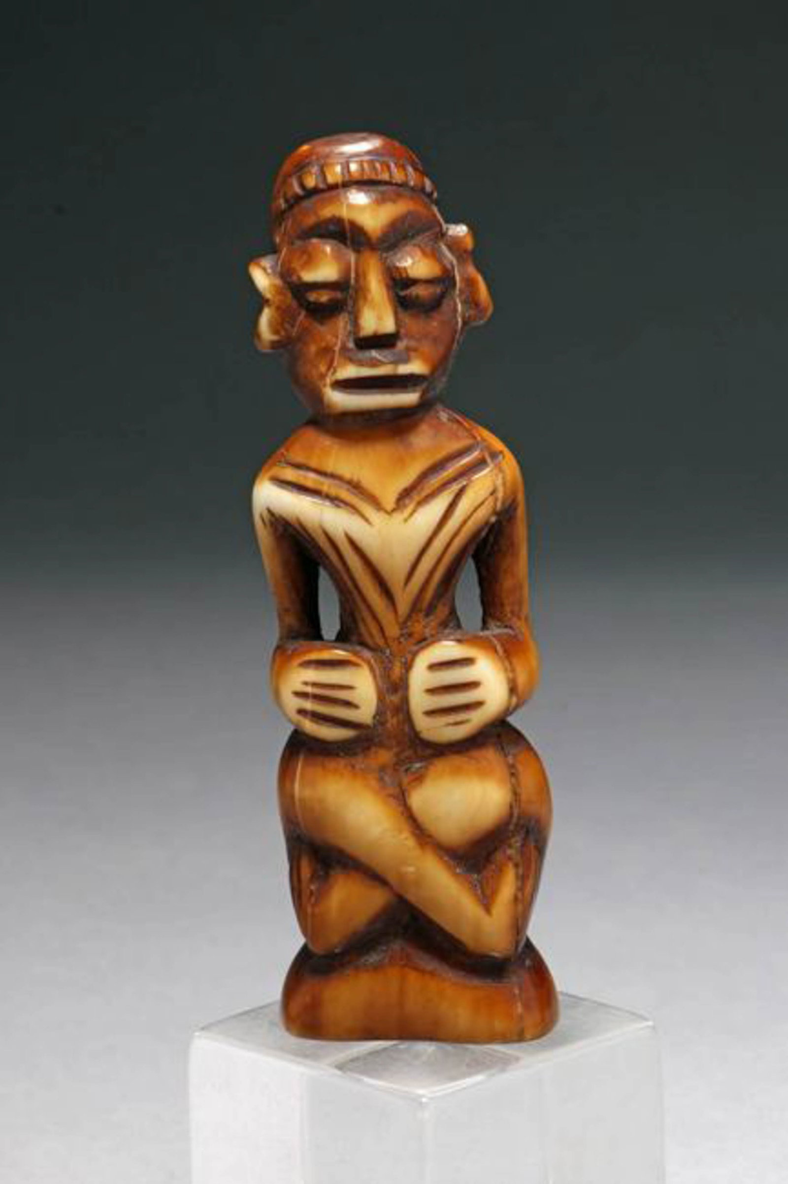 South Pacific Polynesian Figure: A boar tusk carving crossed leg figure. 3-3/4" H Provenance: Ex Mass collection