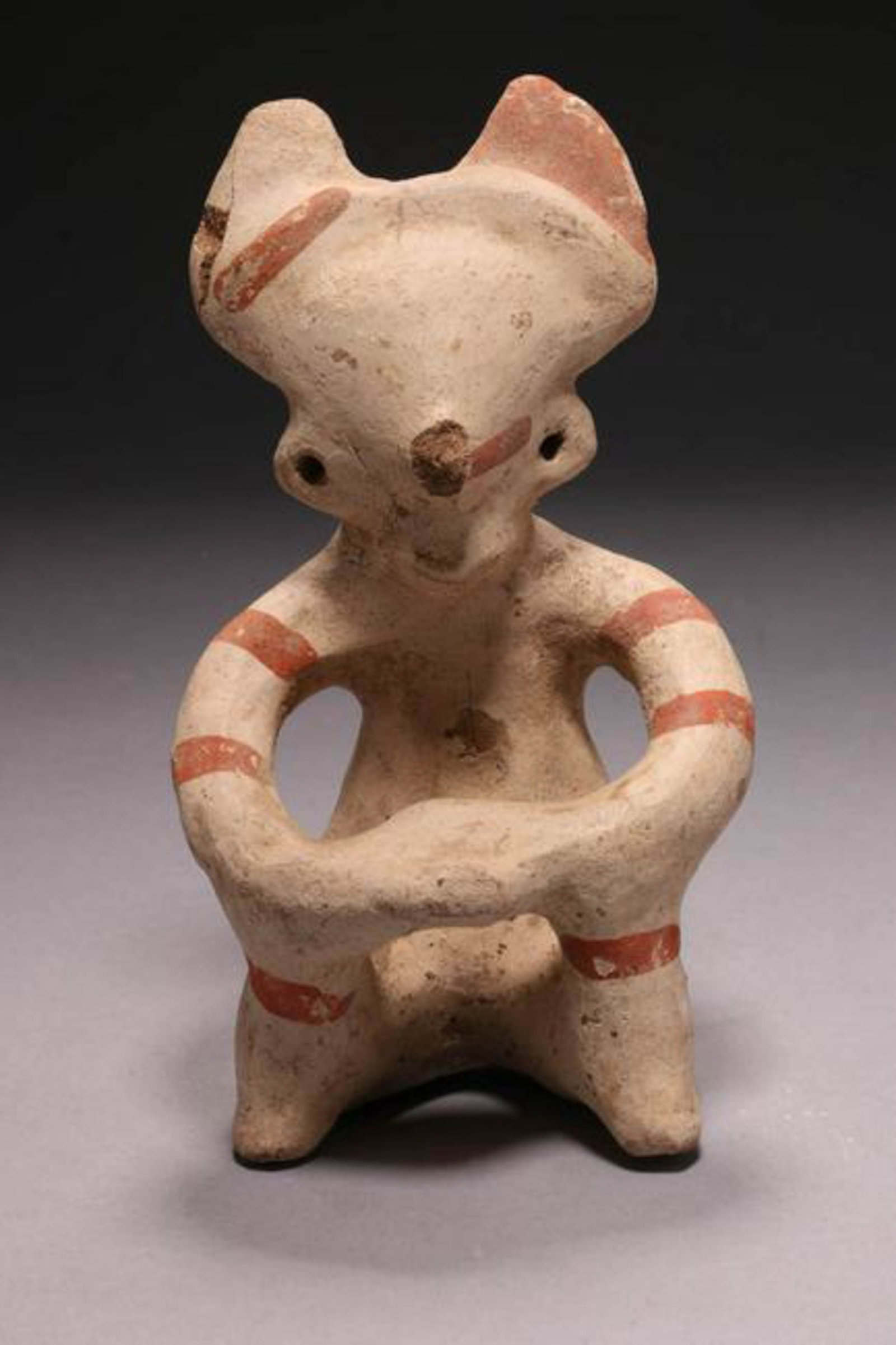 Pre-Columbian Figure: A terracotta figure, cream ground, red highlights. Seating position. 5-3/4" H. Provenance: Ex. Mass collection