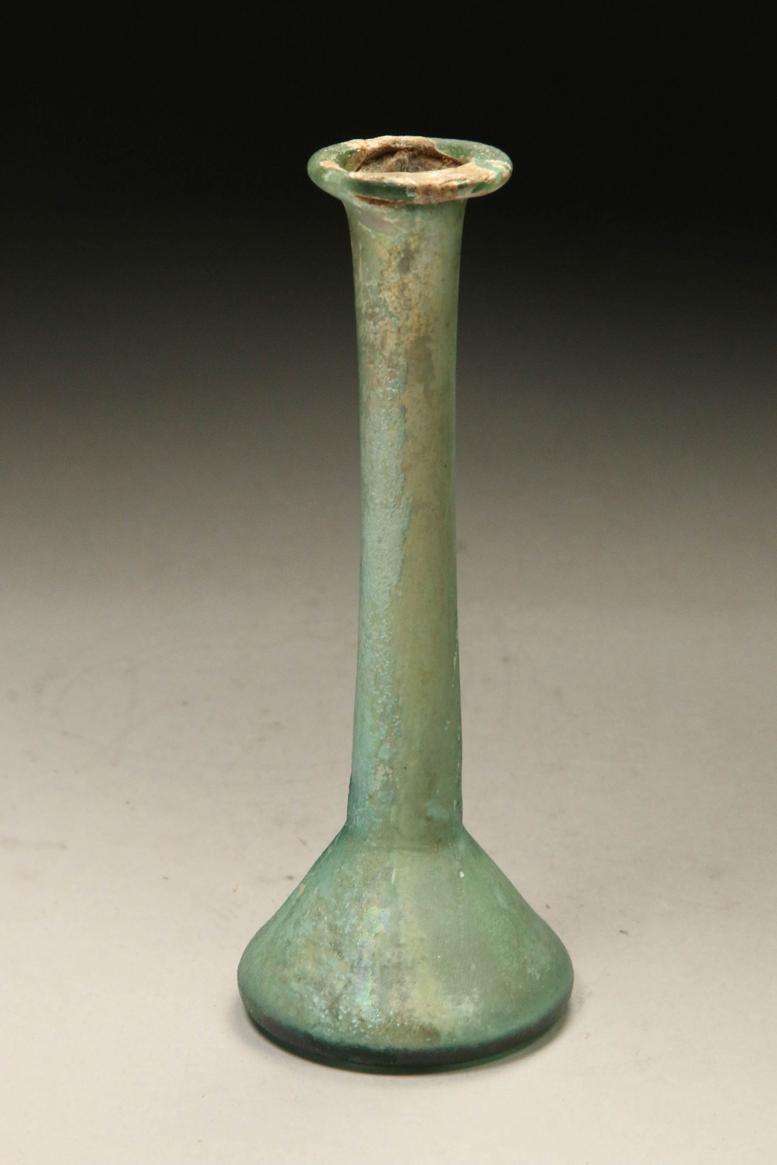 Ancient Roman Glass Unguentarium: A long neck glass bottle with flat bottom and wide rimmed mouth. Lovely iridescence throughout. 6" H
