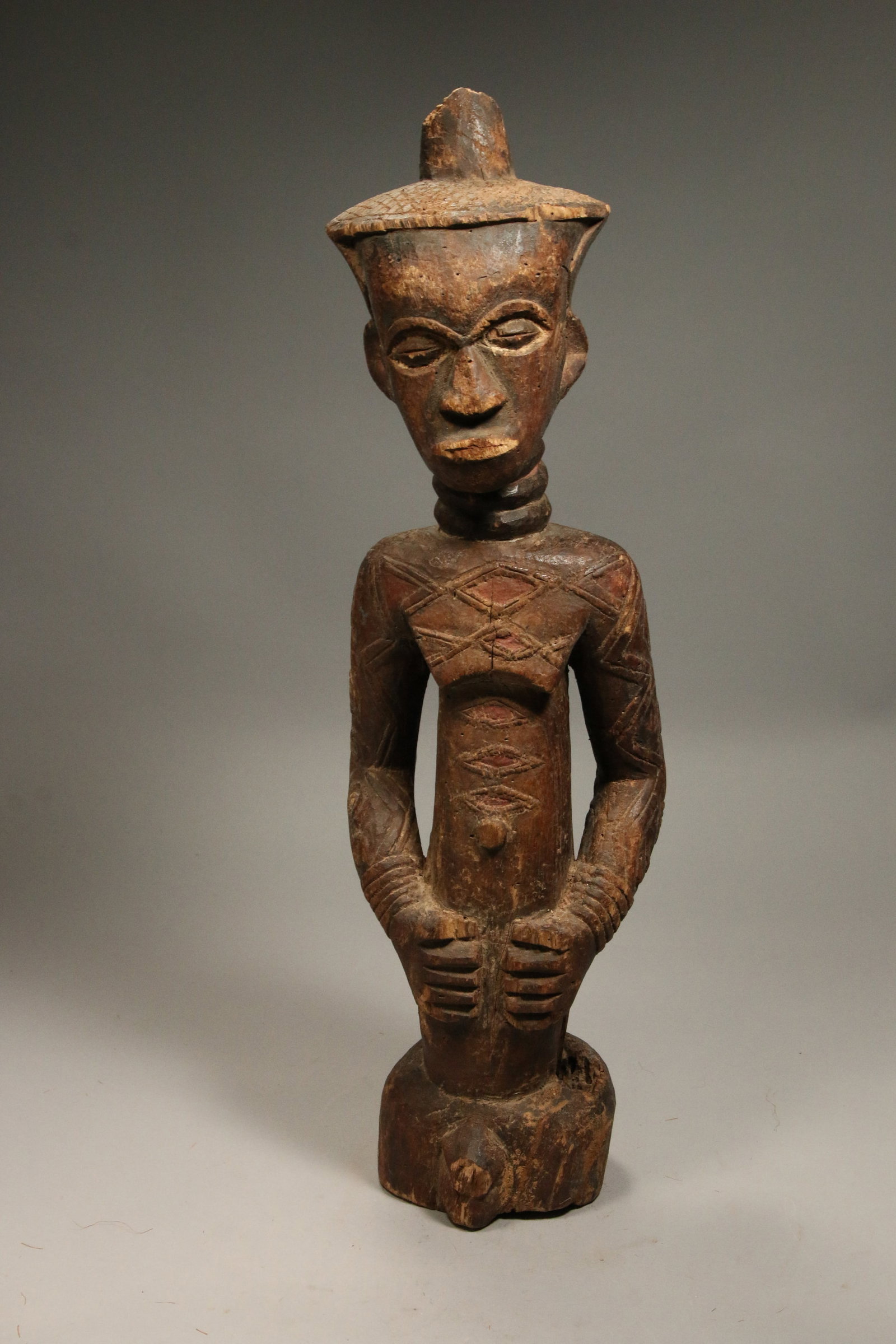 African Art Wood Statute Congo: A Dengese wood statute, Democratic Republic of Congo, scarification throughout body, banded neck rings, wearing a cap and arm bracelets. 23" H See equivalent, Metropolitan Museum of Art, Rockefeller c