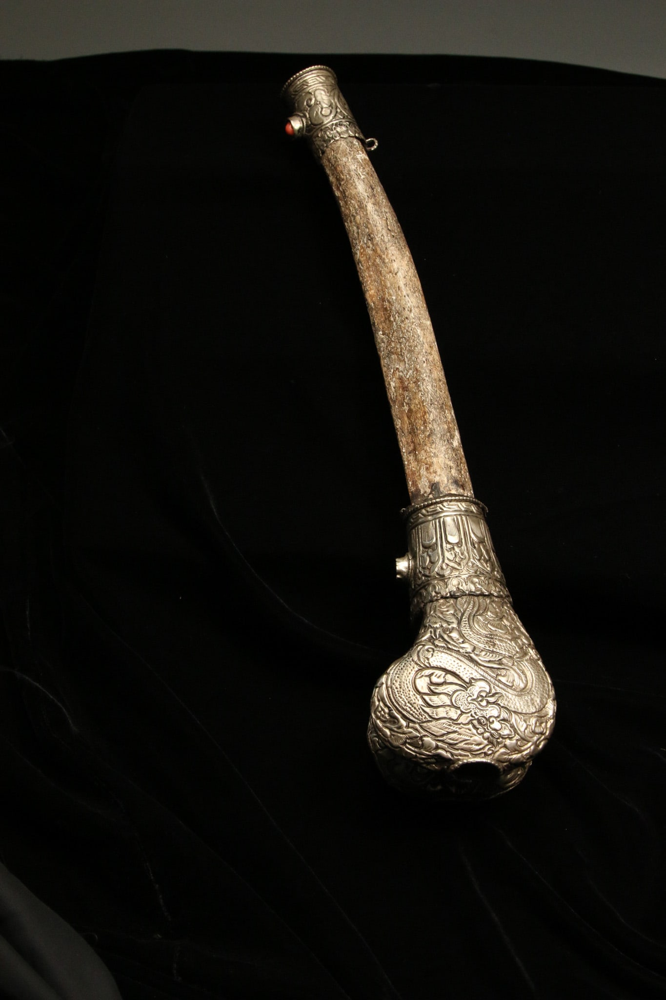 Kangling Trumpet 19th C. Tibetan: A 19th century silver and bone Kangling Trumpet, Tibet. A trumpet carved from a human femur with silver and stone embellishments. The sterling silver sheets are molded around the ends of the bone to f