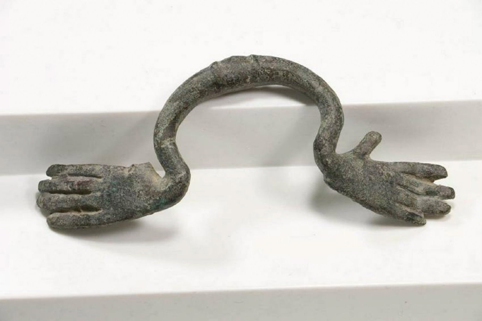 Roman Bronze Hydria Handle circa 100 B.C. - 100 A.D.: Roman Bronze Hydria Handle. One of three handles used on a large pot (Hydria) for carrying water. The handle has hands on either side and two raised lines at the pinnacle of the handle. Nice blue/gree