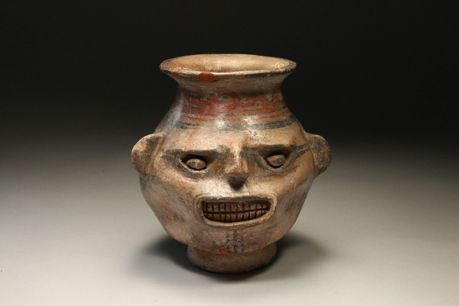 Pre-Columbian Nicoya Portrait Head Vessel: A terracotta portrait head vessel with toothy grimace, hatch design on reverse and sides. 8" H x 8" W; 3 Lbs. 9 oz. Provenance: Ex collection, Brooklyn, NY acquired from Art for Eternity.