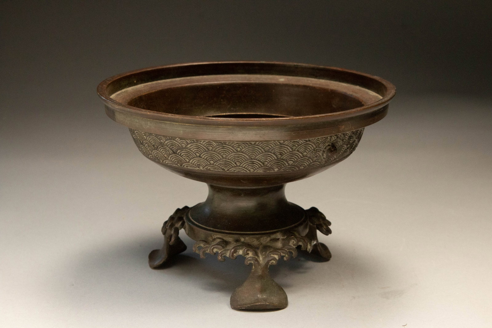 Japanese Bronze Usubata: Japanese Usubata, bronze, Edo period. Wave design on side. Tripod legs. Signed on bottom. 5" H x 7-1/2" W; 3 Lbs. Usubata is a traditional Japanese vessel used for holding and displaying flower arrang