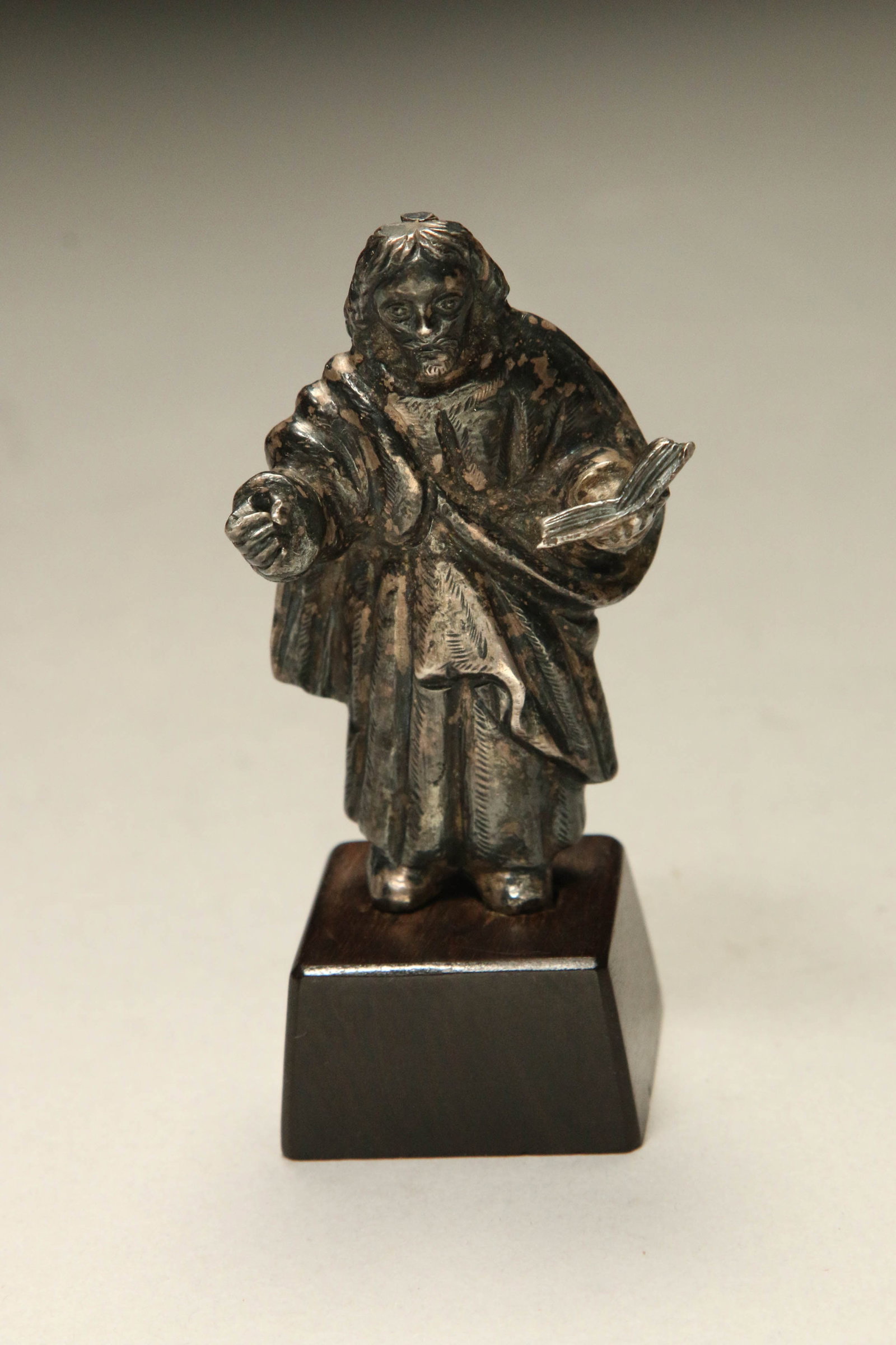 Spanish Colonial Silver Santos: A solid silver Spanish Colonial Santos wearing robes and holding the Book.