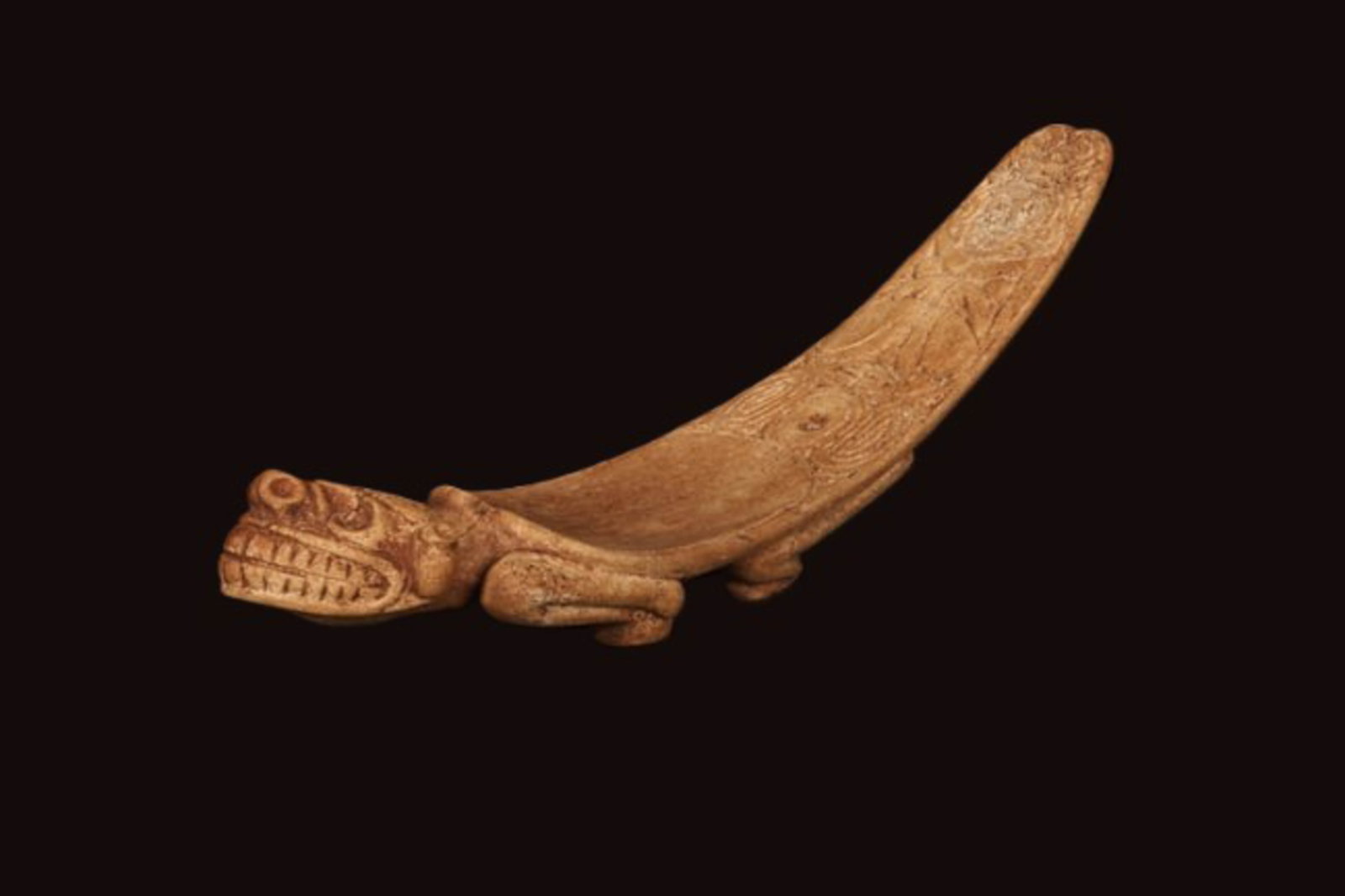 Pre-Columbian Bone Duho - Taino: A small manatee bone Duho, Taino culture with Zemi face on front, inscribed design on top rear, standing on four feet on reverse with male organ. 10-1/2" L x 2-1/4" W Provenance: Ex collection, N.J.; 